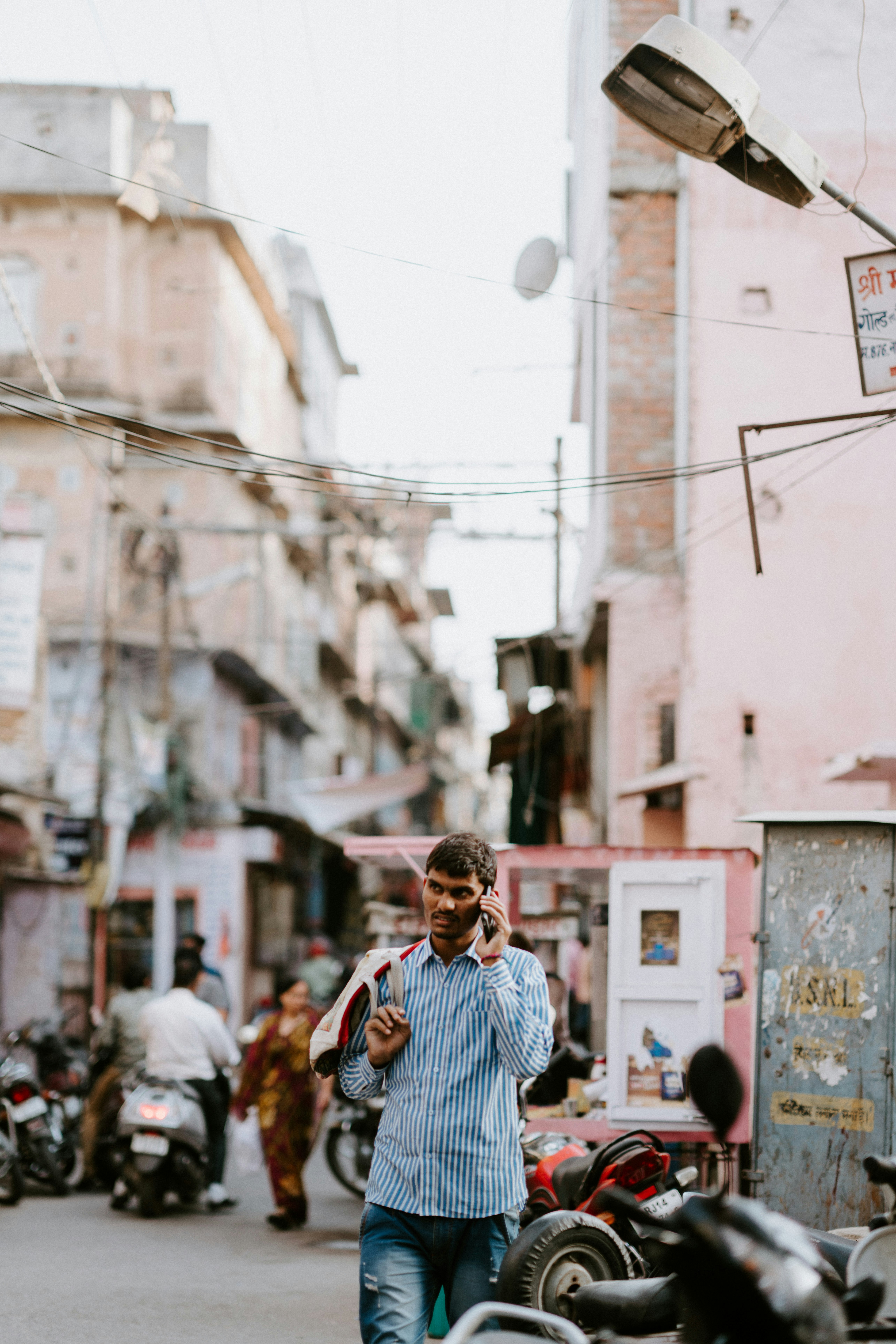 man walking beside the motorcycle and holding smartphone